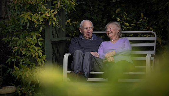 senior-couple-on-garden-bench-preventing-peristomal-skin-problems